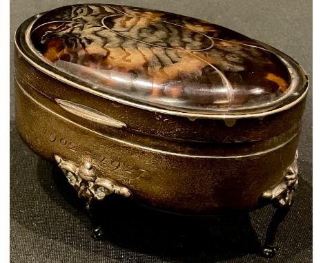 A George V silver and tortoiseshell oval dressing table trinket pot and cover, resting on four slender cabriole legs, pad fee