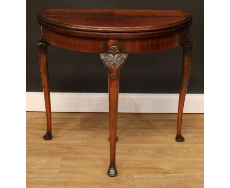 A George II Revival demilune card table, hinged top enclosing a baize lined playing surface, straightened cabriole legs, pad 