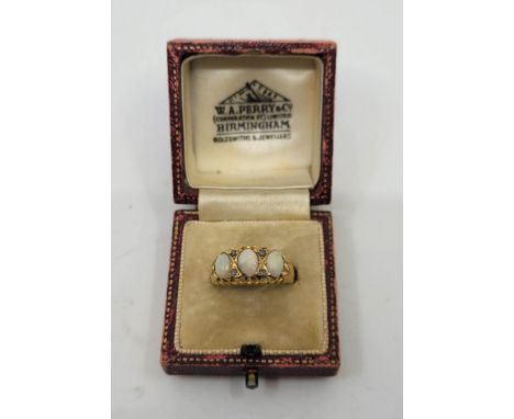 An 18ct. gold, diamond and opal ring, Birmingham 1906, set three oval cabochon opals alternating two pairs of rose cut diamon