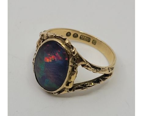 A 9ct. gold and synthetic opal ring,&nbsp;London 1971, having foil backed oval cabochon synthetic opal in rub over setting to