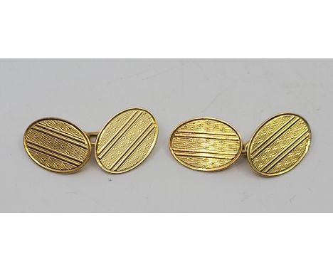 A pair of 18ct. gold oval engine turned cufflinks, chain fitting. (8.4g)  