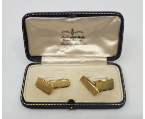 A pair of 18ct. gold rectangular engine turned cufflinks, chain fitting. (9.2g), in jewellers box.   