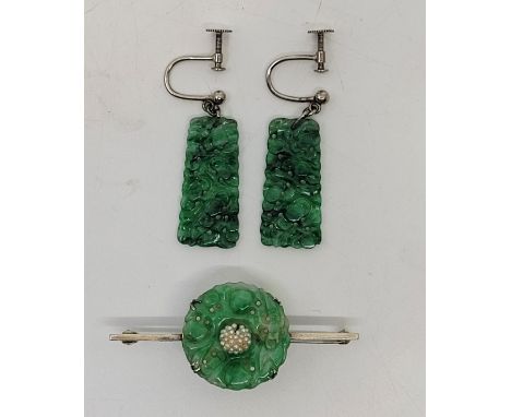 A pair of 18ct. white gold and jade drop earrings, the mottled green jade tapering drops pierced and carved with foliate desi