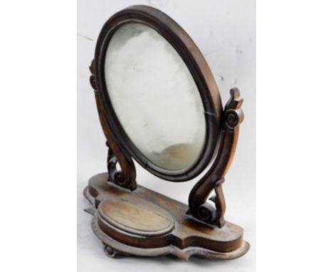 A Victorian mahogany dressing table mirror, the oval plate on shaped supports, the shaped base with a central hinged trinket 
