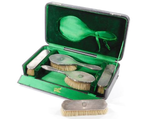 A George V five piece silver backed toilet set, with engine turned sunburst decoration, circle reserved monogram engraved, co