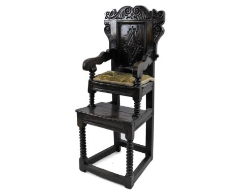 A late 17thC/early 18thC oak child's highchair, the shaped back with scrolls above a panel decorated with a lozenge, the shap