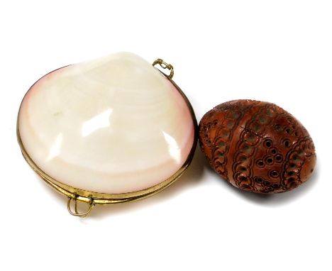 A mother of pearl clam shell trinket box and a nut trinket box with carved and etched engraving.  (2)