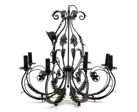 A metal eight branch chandelier, with inverted leafy capped S scroll supports and candle dish holders, on a central cylindric