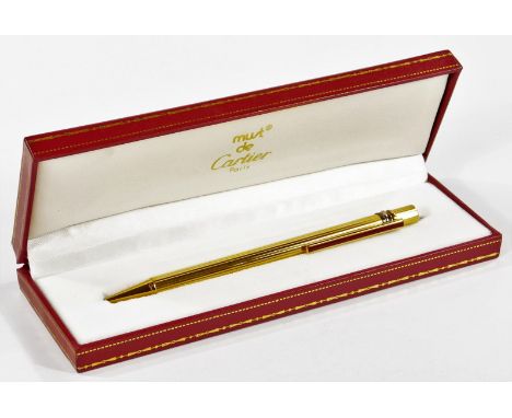 A cased Must De Cartier ballpoint pen, part engine turned with rotating action, 13cm W.  (cased)