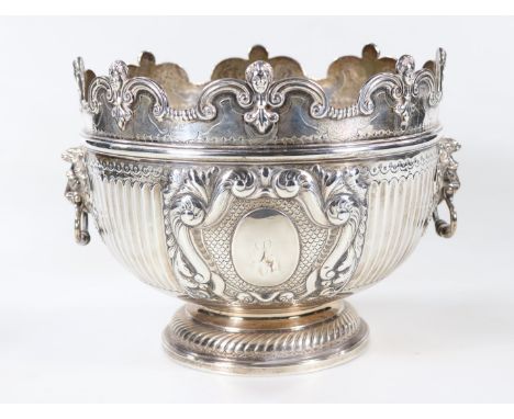 A late Victorian silver Monteith bowl, with scroll and mask head border, fluted body, with two lions head ring handles and wi