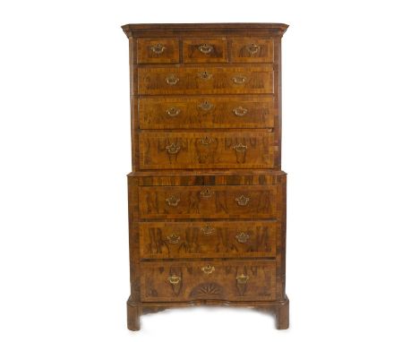 An early 18thC figured walnut chest on chest or tall boy, with moulded cornice, fluted canted corners, enclosing three short 