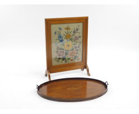 An Edwardian mahogany tea tray, with galleried edge, metal handles and central oval shell patera, 77cm W and an embroidered f