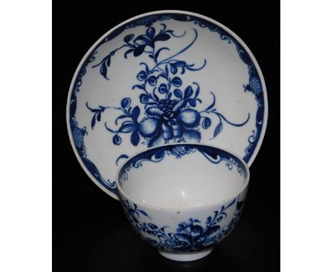 An 18thC Worcester blue and white hand painted tea bowl and saucer, decorated with sprays of flowers and scrolling border.