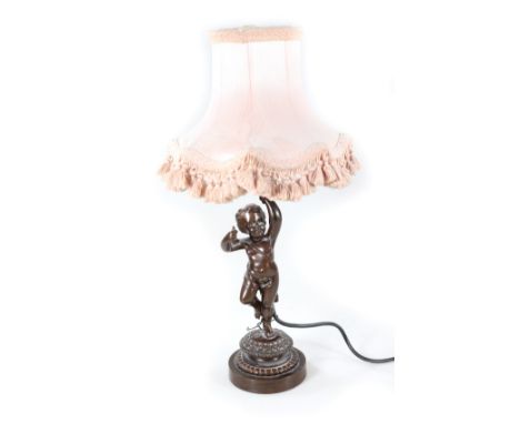 A late 19thC/early 20thC bronze lamp base, modelled in the form of a putto holding the light fitting on a circular base with 