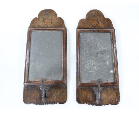 A pair of 18thC oak wall sconces, each inlaid with a star above a rectangular plate and a single wrought iron candle stick wi