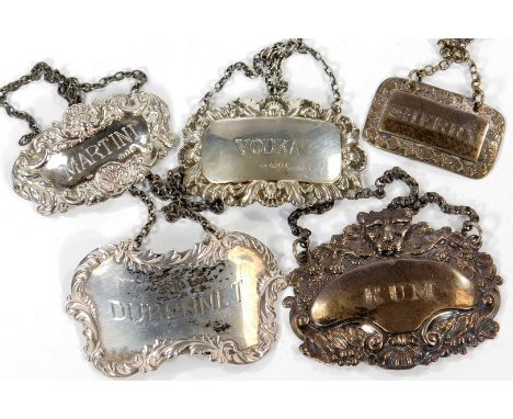 A George IV silver decanter label, embossed with a leopard's head and vines engraved for Rum, Sheffield 1821, and four furthe