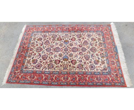 An Isfahan rug, the central cream ground with all-over stylised and foliate decoration in pale terracotta, blue, green and ma