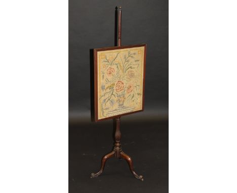 A late Regency mahogany tapestry pole screen, the rectangular needlework fire screen decorated with a vase of flower in gros 