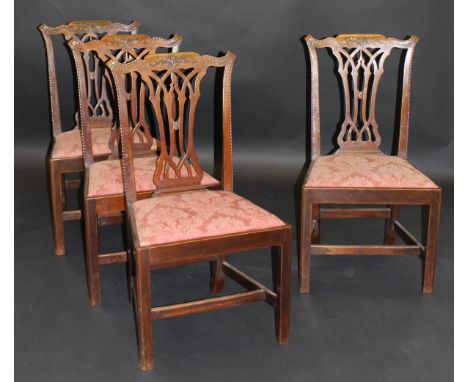 A set of four 19th Century mahogany Chippendale style dining chairs with acanthus and rope twist decorated top rail over a pi