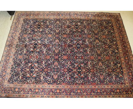 A Persian carpet, the centrefield with all-over stylised floral and foliate decoration in terracotta, peach, cream and blue o