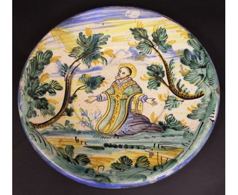 An 18th Century Italian Maiolica charger decorated with kneeling Saint, the light of the Lord shining down upon him, 39.5 cm 