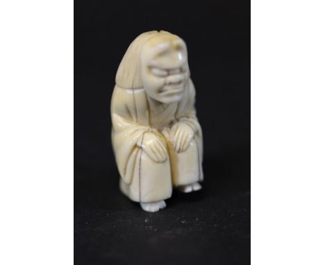 A 19th Century Japanese Meiji period carved ivory netsuke as a seated theatrical figure wearing a mask, unsigned (possibly fo