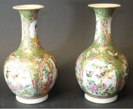 A pair of circa 1900 Chinese Canton famille-rose vases of onion form with flared rims, decorated with panels of figures in in