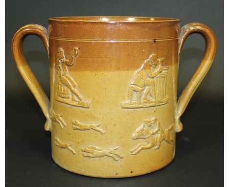 An over-sized 19th Century salt-glazed loving mug decorated in relief with stag-hunting scene and topers, 19.1 cm diameter ex