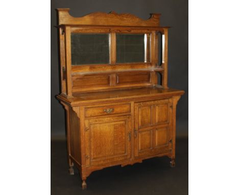 An oak Arts & Crafts mirror back sideboard, the superstructure with a pair of mirrors above a shaped shelf, flanked by fluted