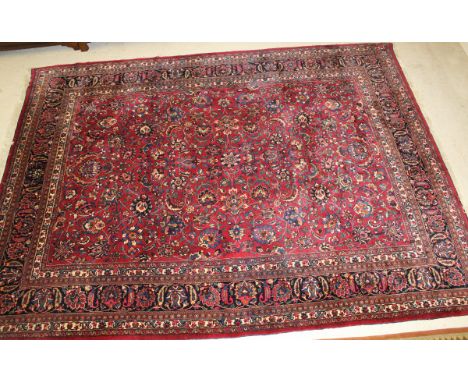 A Persian carpet, the all-over stylised floral and foliate decoration in blue, cream, pink and teal on a pale burgundy ground
