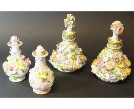 A pair of early 19th Century floral encrusted porcelain scent bottles of pear form with stoppers, 16 cm high, together with t