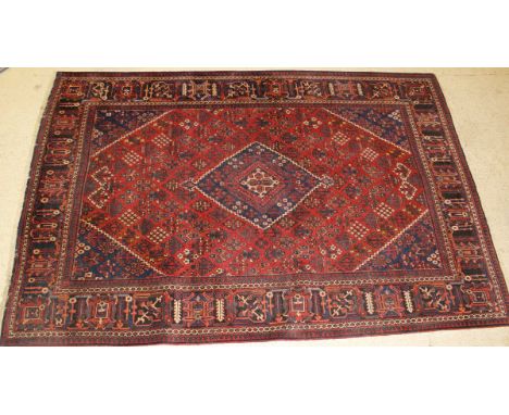 A Persian carpet, the central diamond shaped medallion in dark blue, terracotta and cream on a terracotta stylised floral mot