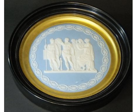 A 19th Century Wedgwood blue jasper dip circular wall plaque decorated with classical figures within a foliate border, 15 cm 