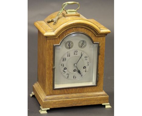 An early 20th Century oak cased mantel clock, the domed case enclosing a silvered dial with chime and silent / slow/fast dial