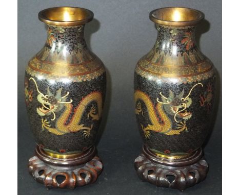 A pair of early 20th Century Chinese cloisonné vases with flared rims, the body decorated with five toed dragon raised on mat