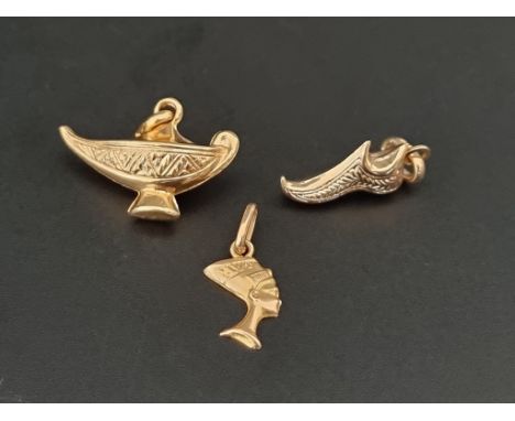 Two Iranian yellow metal charms, stamped 750; comprising a lantern and a shoe; together&nbsp; with a similar pendant decorate