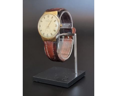 A vintage National Watch yellow metal manual wind wristwatch, stamped 18k, 34mm, Serial No.333809, on leather strap. 