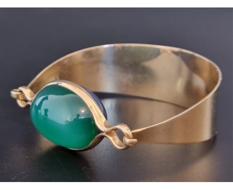 A vintage Spanish yellow metal bangle, set two oval cabochon semi precious gems, by Puig Doria, No.6978, maximum internal wid
