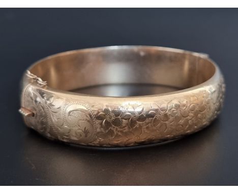 A 9ct gold hinged bangle, 62mm maximum internal size, 21g. 