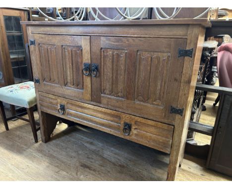 An oak Arts &amp; Crafts style side cabinet, having two doors above a single drawer, 127 cm wide