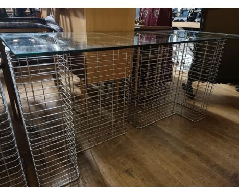 A Habitat chrome metal and glass deskGlass top 60 x 150 cm  wire racks 40 x 68 cm each Some light wear through the lot, due t