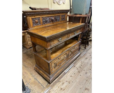 A late 19th/early 20th century walnut buffet, by James Shoolbred &amp; Co, having a carved raised back, above two drawers to 