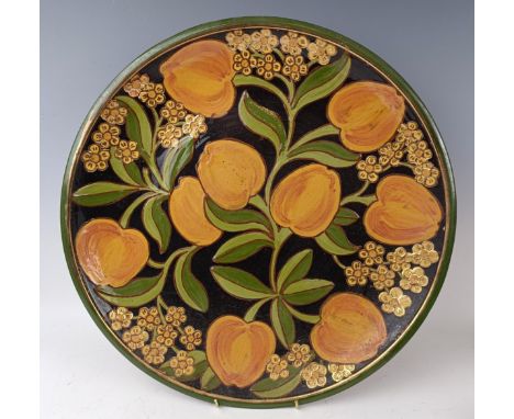 An earthenware charger, decorated peaches and flowers, 42 cm diameter