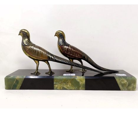 A pair of painted silver coloured metal pheasants, on a marble base, 40 cm wide