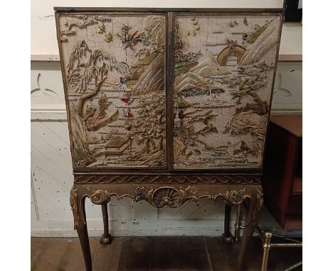 A Chinese style drinks cabinet, the sides inset with plaster relief decorated landscapes, with two doors, 94 cm wide