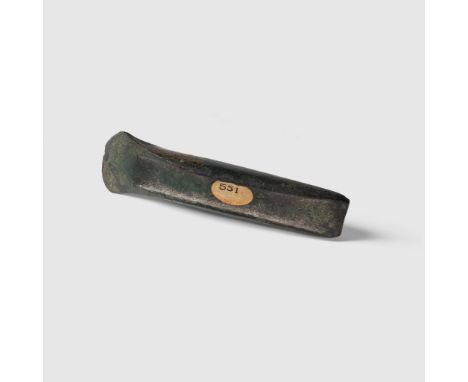 FLANGED AXE BRONZE AGE, C. 1400 B.C. cast copper alloy, with raised flanges and short curving blade, old inventory label, rea
