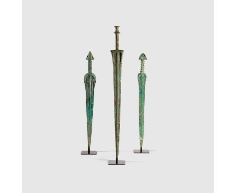 TRIO OF NEAR EASTERN SWORDS NEAR EAST, EARLY FIRST MILLENIUM B.C. cast bronze, consisting of one sword with inlaid pommel and