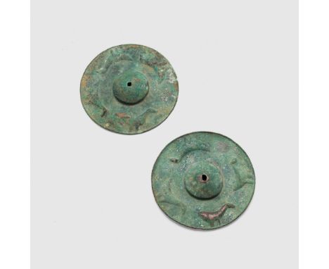 PAIR OF NEAR EASTERN SHIELD BOSSES NEAR EAST, 1ST MILLENIUM B.C. hammered bronze, both with a central domed projection, the b