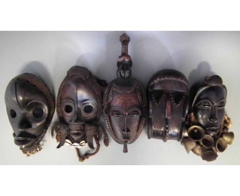 Gre mask, two Dan masks, a Baule mask and one other mask decorated with bells, the largest mask measures 37cm high     All lo