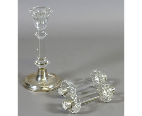 A silver based candlestick and a pair of glass knife rests with silver terminals.